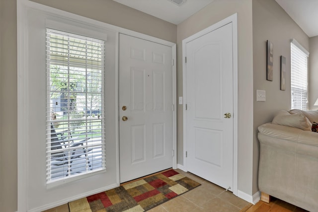 foyer entrance featuring baseboards and light tile patterned floors