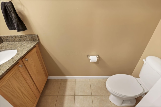 half bathroom featuring toilet, baseboards, tile patterned flooring, and vanity