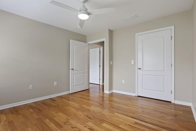 unfurnished bedroom featuring baseboards, ceiling fan, light wood-style flooring, and visible vents
