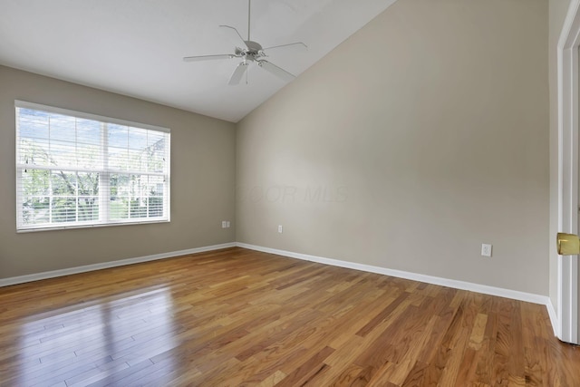 spare room featuring baseboards, light wood-style flooring, ceiling fan, and lofted ceiling