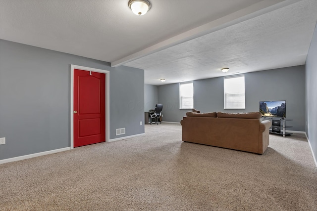 living room featuring visible vents, carpet, baseboards, and beam ceiling