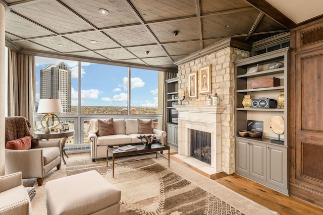 living room with light wood-style floors, floor to ceiling windows, plenty of natural light, and a fireplace