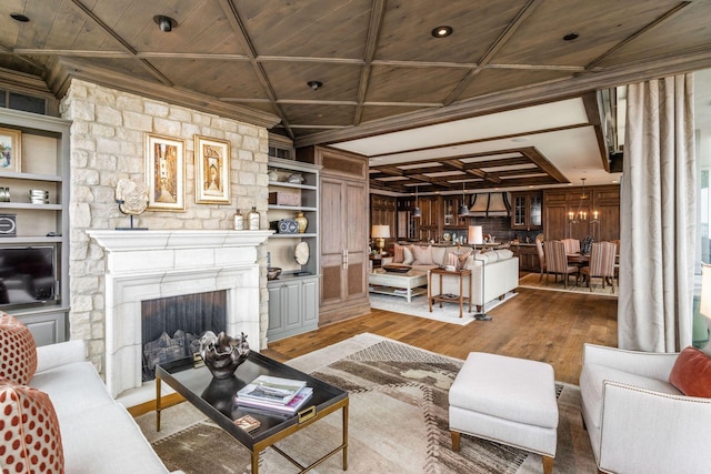 living room with wood ceiling, built in features, a fireplace, wood finished floors, and ornamental molding
