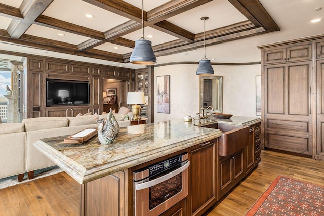 kitchen with light wood-style floors, open floor plan, and beamed ceiling