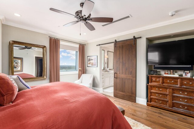 1 Miranova Pl Unit 2230, Columbus, OH 43215 - bedroom featuring crown molding, a barn door, baseboards, light wood-style floors, and ensuite bathroom