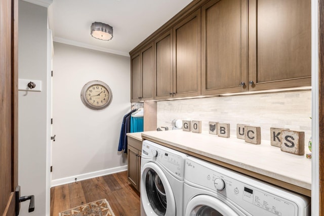 washroom featuring crown molding, dark wood finished floors, cabinet space, baseboards, and separate washer and dryer