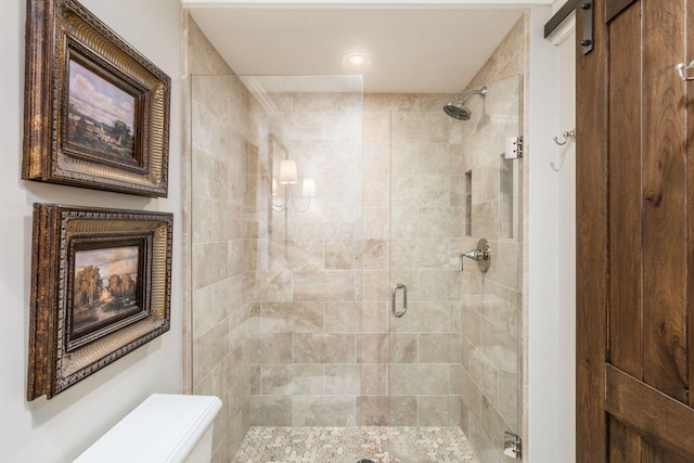 bathroom with toilet and a shower stall