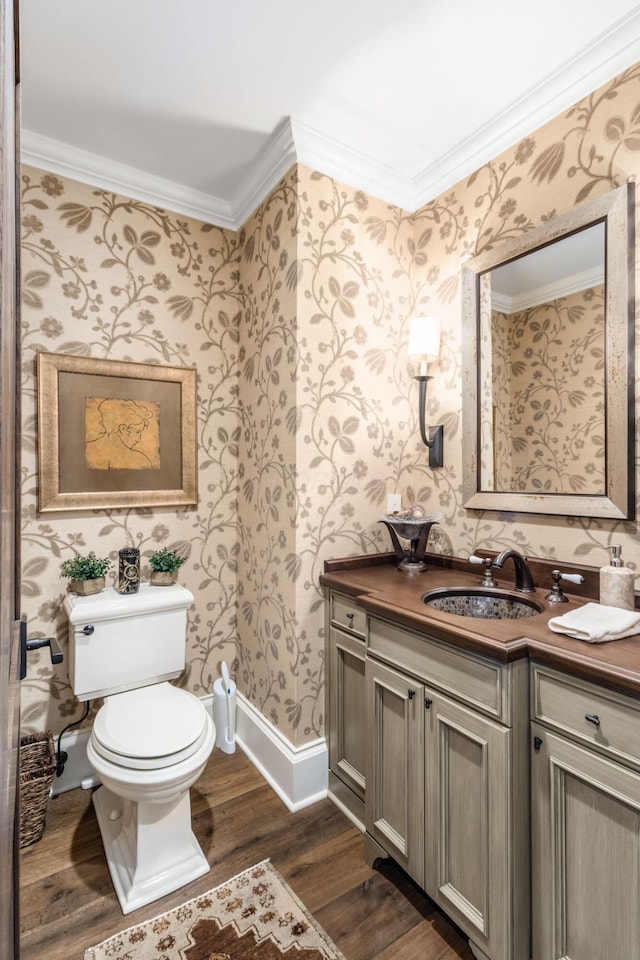 bathroom with ornamental molding, wood finished floors, toilet, and wallpapered walls