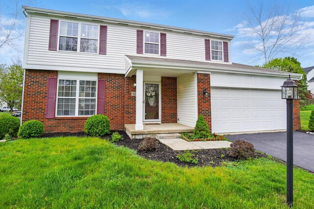 7622 Elgin Trail Dr, Blacklick, OH 43004 - view of front of home featuring aphalt driveway, brick siding, and a front yard