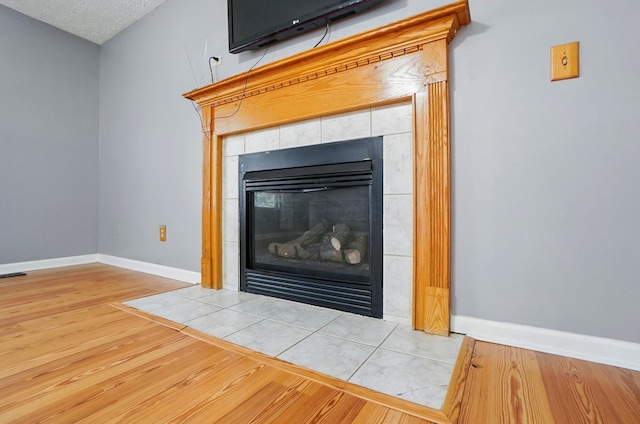 7622 Elgin Trail Dr, Blacklick, OH 43004 - room details featuring a tile fireplace, baseboards, and wood finished floors