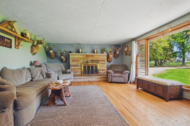 living area featuring light wood-style floors and a glass covered fireplace