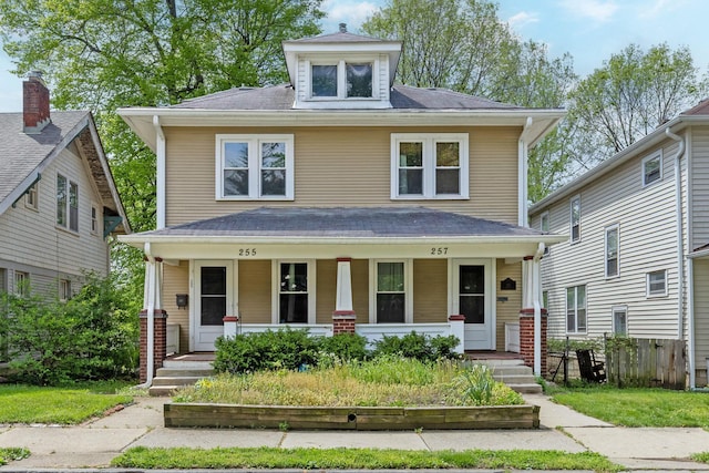 traditional style home with covered porch and fence