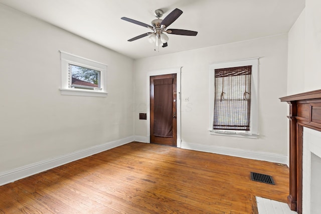 interior space with ceiling fan, baseboards, visible vents, and wood finished floors