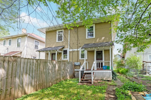 rear view of house featuring a fenced backyard