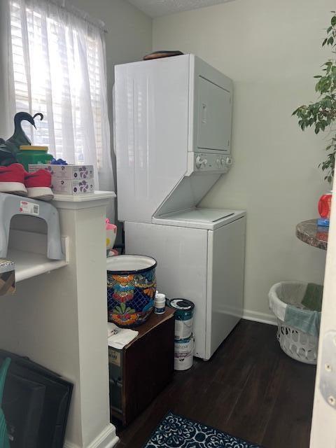 4708 Parrau Dr Unit 60D, Columbus, OH 43228 - laundry area featuring stacked washer and clothes dryer, dark wood-type flooring, and baseboards