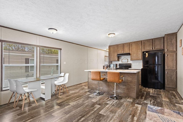 4711 Walnut Rd Lot K-5, Buckeye Lake, OH 43008 - kitchen with light countertops, dark wood-style floors, black appliances, and a center island with sink