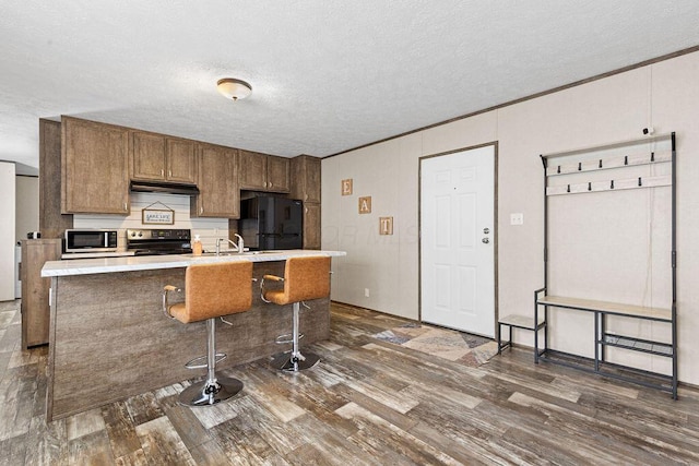 4711 Walnut Rd Lot K-5, Buckeye Lake, OH 43008 - kitchen with dark wood-style flooring, a textured ceiling, electric stove, freestanding refrigerator, and stainless steel microwave