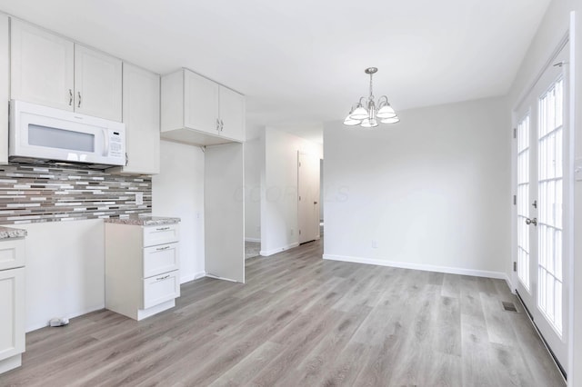 311 Williamsburg Ln NW, Lancaster, OH 43130 - kitchen featuring light wood finished floors, backsplash, white microwave, and white cabinets