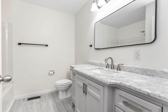 311 Williamsburg Ln NW, Lancaster, OH 43130 - full bathroom featuring vanity, toilet, baseboards, a tub to relax in, and visible vents
