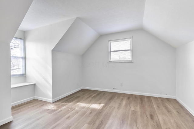311 Williamsburg Ln NW, Lancaster, OH 43130 - additional living space featuring light wood-style floors, baseboards, plenty of natural light, and vaulted ceiling
