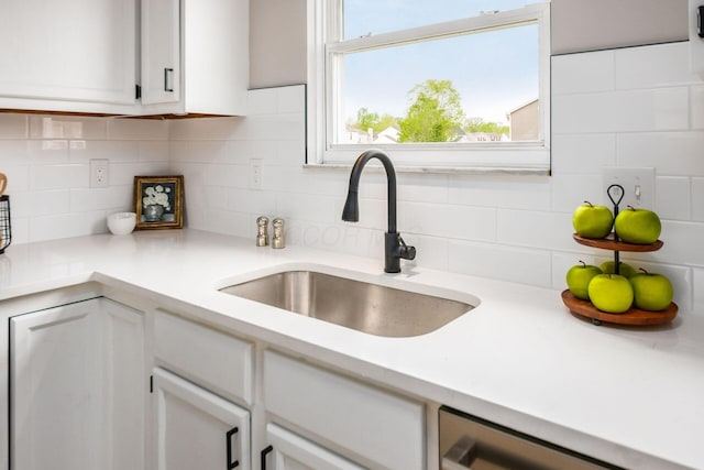 3141 Amberfield Dr, Columbus, OH 43232 - kitchen featuring white cabinets, a sink, dishwasher, light countertops, and backsplash