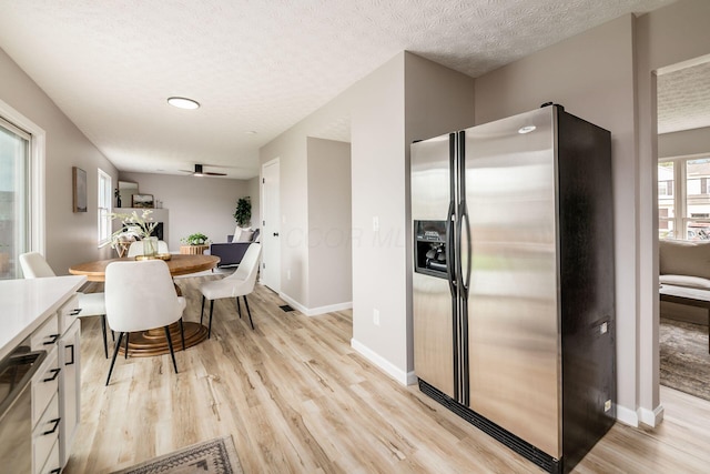 3141 Amberfield Dr, Columbus, OH 43232 - kitchen featuring a textured ceiling, baseboards, light wood finished floors, and stainless steel fridge with ice dispenser