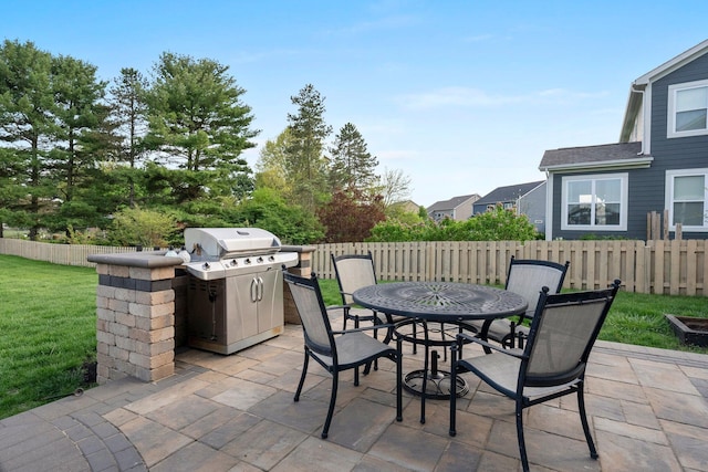 view of patio with fence, area for grilling, and outdoor dining space