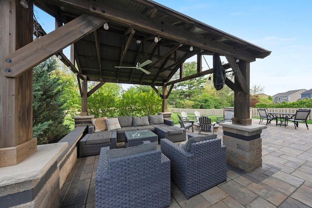 view of patio / terrace with fence, a gazebo, an outdoor hangout area, outdoor dining area, and a ceiling fan