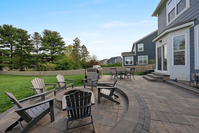 view of patio featuring fence, a fire pit, and entry steps