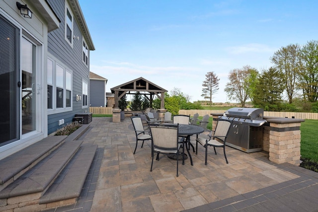 view of patio / terrace with a gazebo, fence, grilling area, and outdoor dining space
