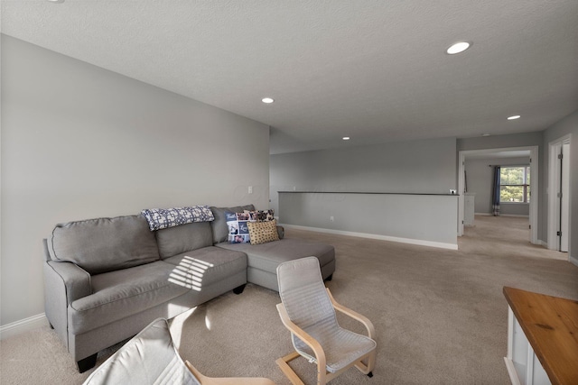 living area featuring recessed lighting, baseboards, light carpet, and a textured ceiling