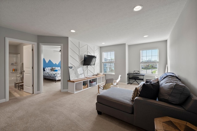 living room with light carpet, baseboards, ceiling fan, recessed lighting, and a textured ceiling