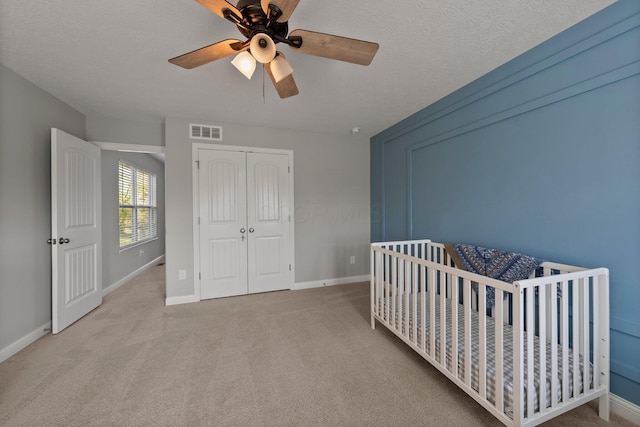 carpeted bedroom with visible vents, a ceiling fan, baseboards, and a closet