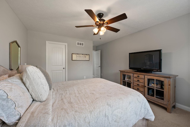 carpeted bedroom featuring baseboards, ceiling fan, and visible vents