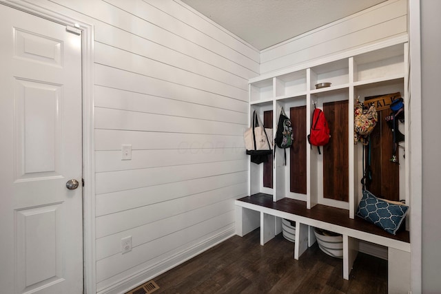 mudroom featuring visible vents, dark wood finished floors, and wooden walls