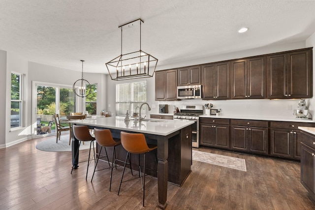 kitchen featuring light countertops, a sink, a textured ceiling, and stainless steel appliances