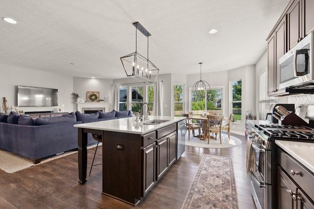 kitchen with light countertops, a sink, dark brown cabinetry, and stainless steel appliances