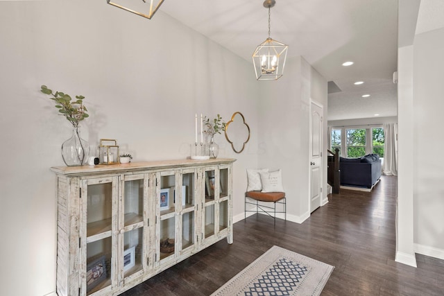 corridor with recessed lighting, baseboards, an inviting chandelier, and wood finished floors