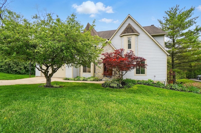 9127 Red Cedar Dr, West Chester, OH 45069 - view of front of house with a garage, stone siding, driveway, and a front yard