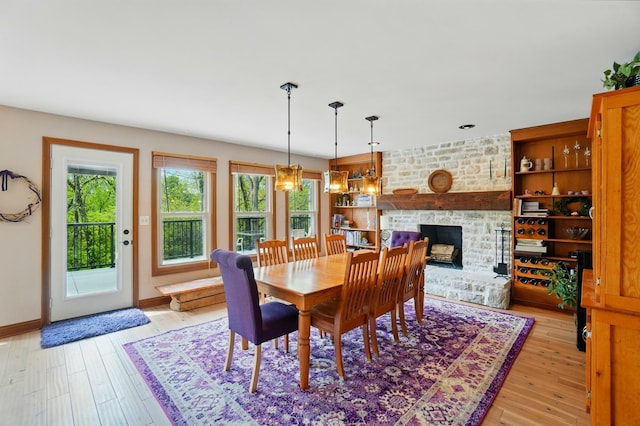 9127 Red Cedar Dr, West Chester, OH 45069 - dining space featuring baseboards, light wood-style flooring, a healthy amount of sunlight, and a fireplace
