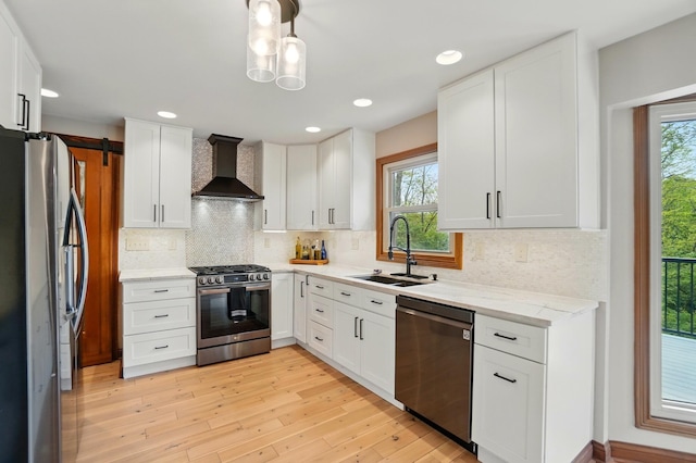 9127 Red Cedar Dr, West Chester, OH 45069 - kitchen with wall chimney range hood, appliances with stainless steel finishes, a sink, and a healthy amount of sunlight