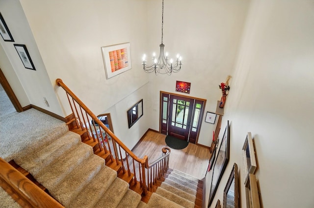 9127 Red Cedar Dr, West Chester, OH 45069 - foyer with a towering ceiling, wood finished floors, baseboards, stairway, and a notable chandelier