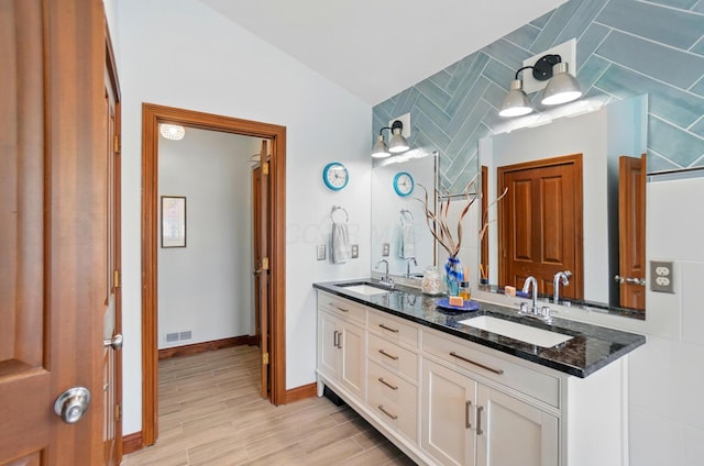 9127 Red Cedar Dr, West Chester, OH 45069 - full bathroom with double vanity, visible vents, a sink, and wood finished floors