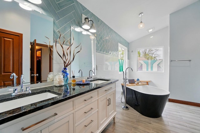 9127 Red Cedar Dr, West Chester, OH 45069 - bathroom featuring double vanity, a soaking tub, a sink, and lofted ceiling