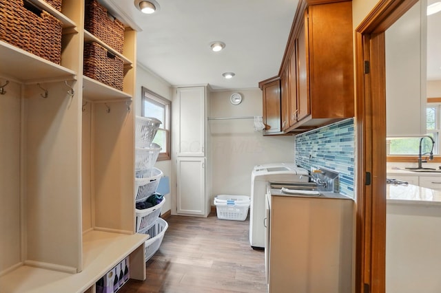 9127 Red Cedar Dr, West Chester, OH 45069 - clothes washing area with a sink, washer / dryer, a healthy amount of sunlight, and wood finished floors