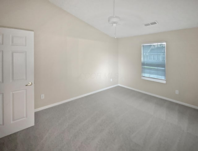 empty room with vaulted ceiling, baseboards, and carpet flooring