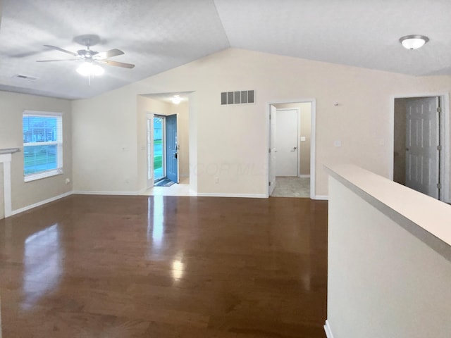 unfurnished room featuring a ceiling fan, vaulted ceiling, wood finished floors, and visible vents