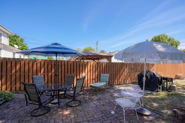 view of patio / terrace featuring a gazebo, outdoor dining area, fence, and grilling area