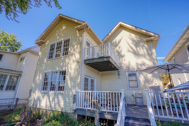 rear view of house featuring a deck and a balcony