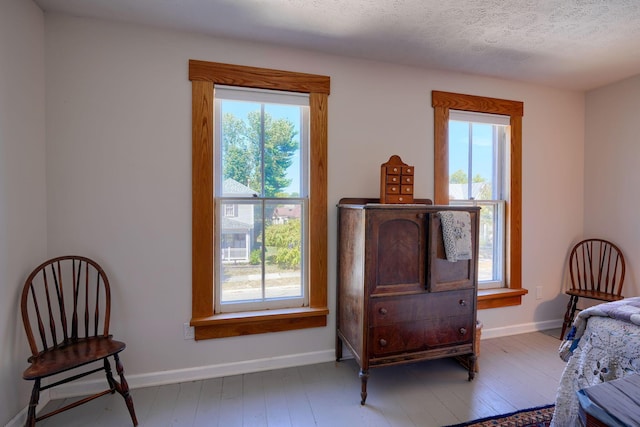 bedroom featuring a textured ceiling, baseboards, and hardwood / wood-style floors